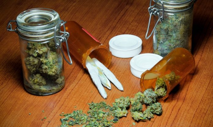 Zwei Einmachgläser mit Marihauna, daneben ein paar Joints und Marihuana-Blüten